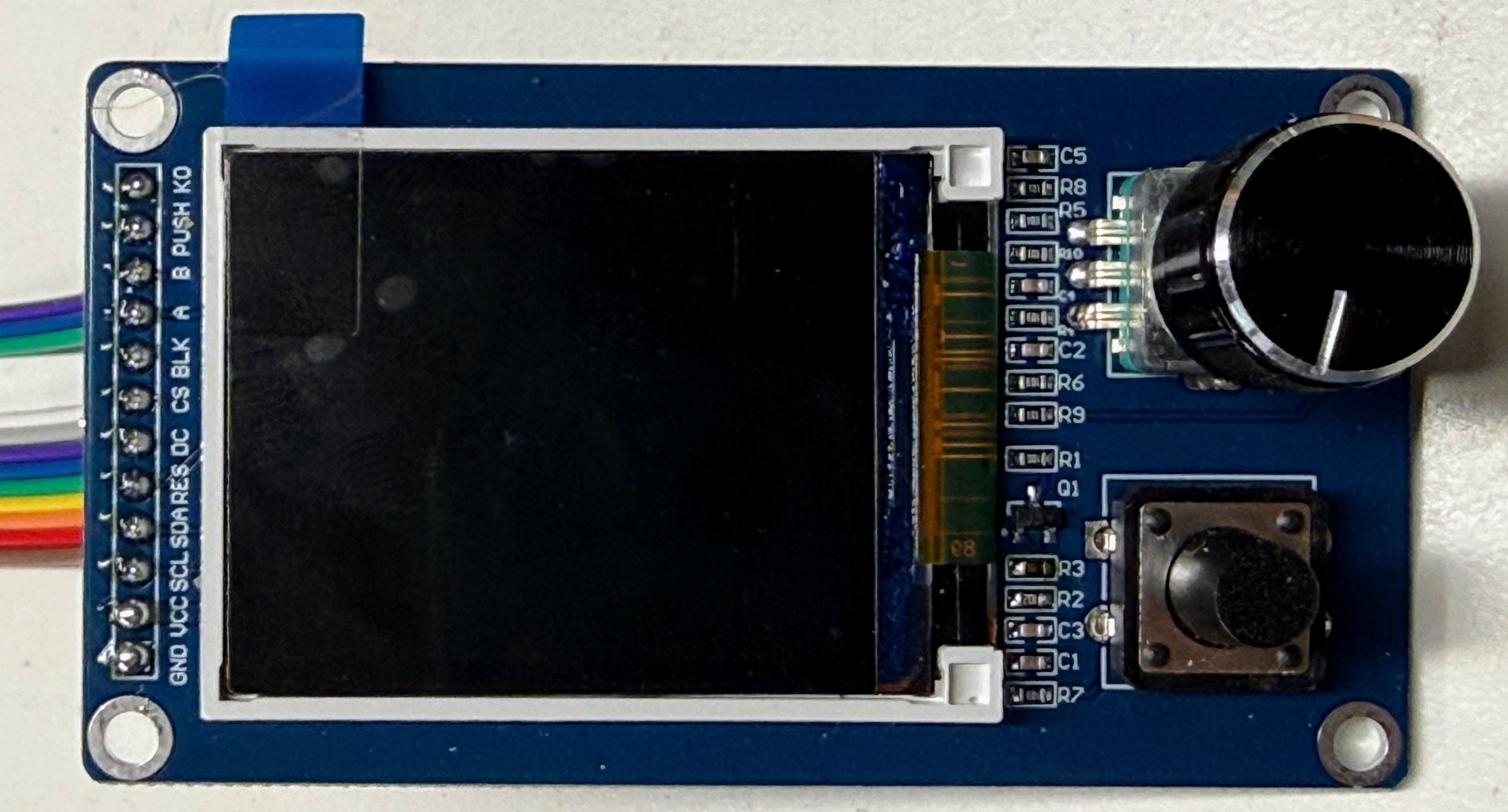 The front of the display board: a row of 12 pins down the left edge, the screen in the middle, and the round knob and square K0 button on the right
