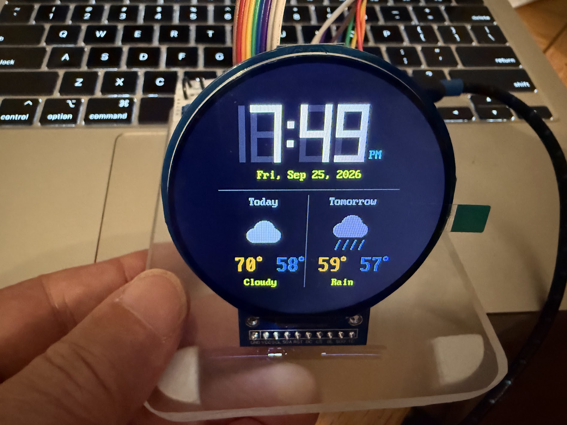 The smartwatch kit showing the weather clock: 7:49 PM, cloudy today, rain tomorrow