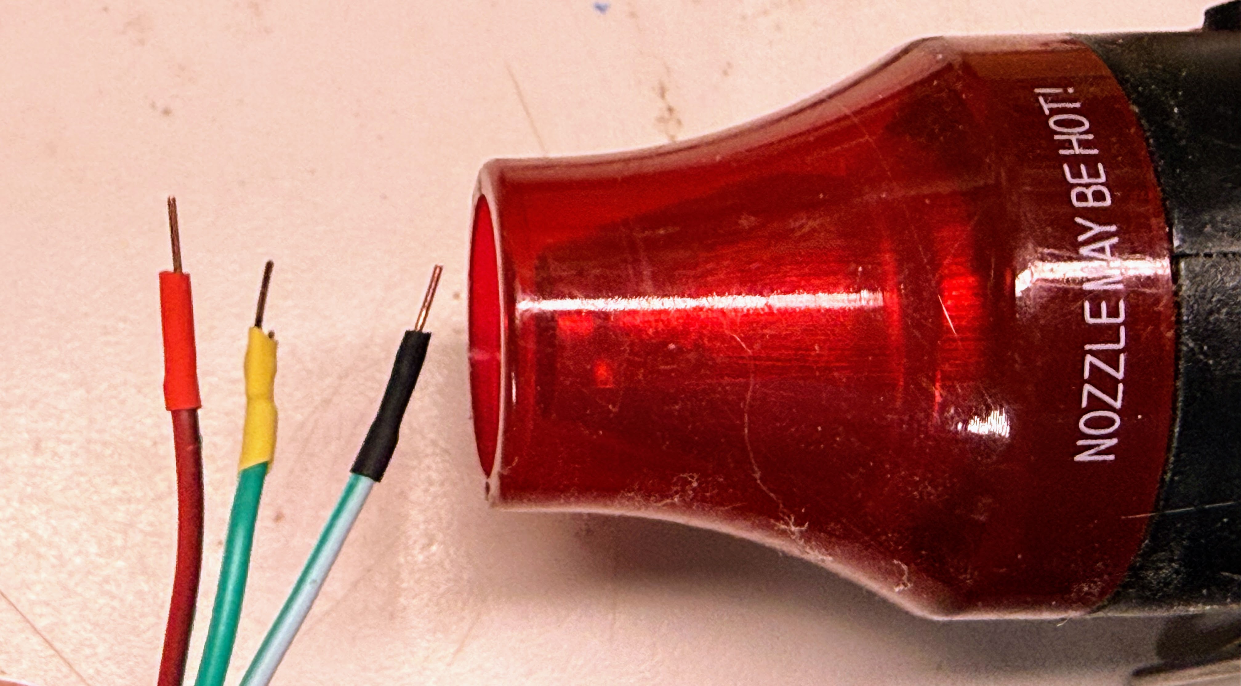 Heat gun shrinking colored tubing over the soldered wire joints